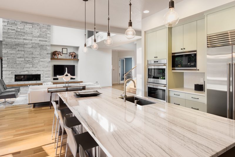 Remodelled Bakersfield kitchen with a stone island, custom cabinetry and pendant lighting
